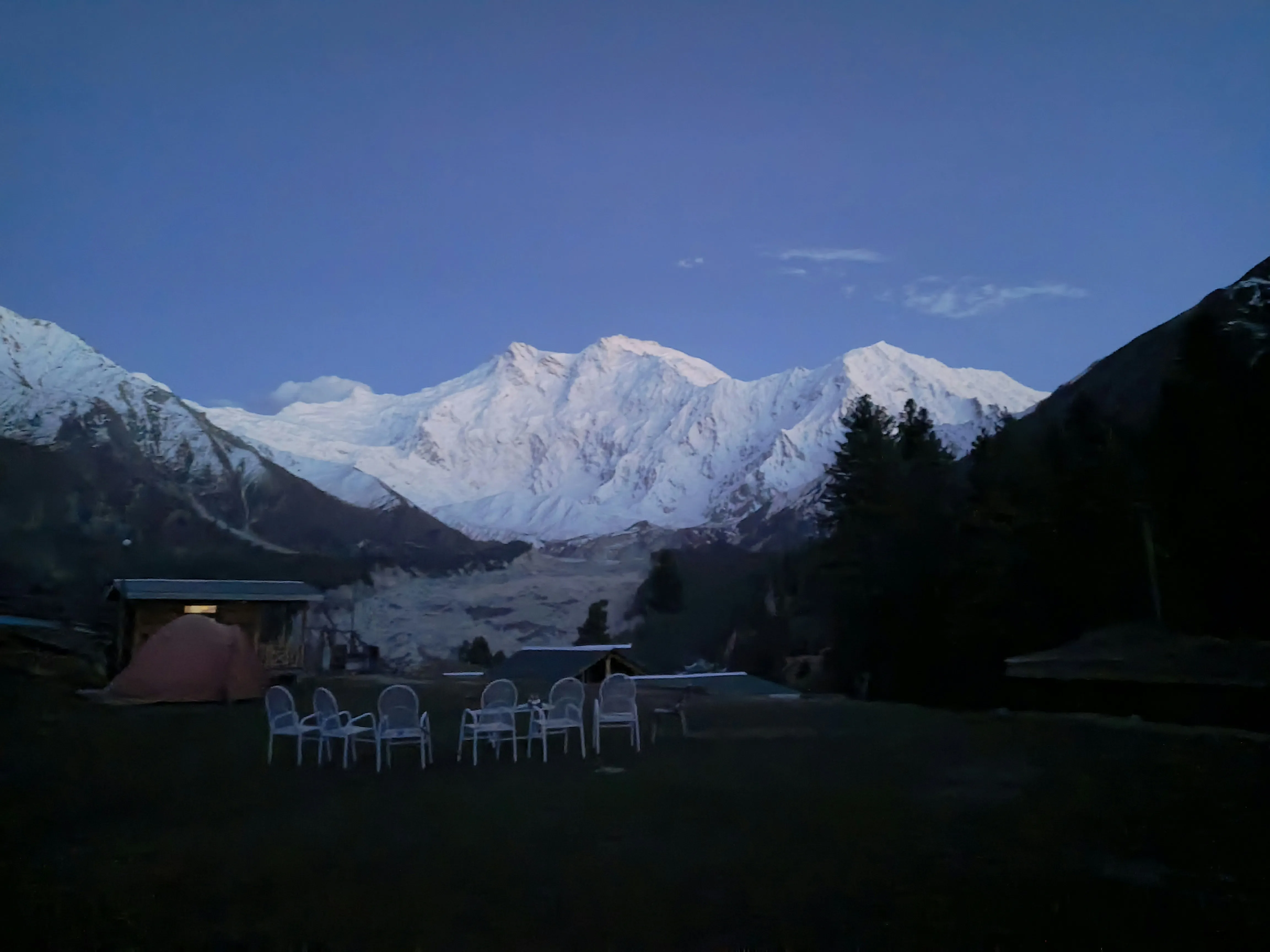Camp chairs facing Nanga Parbat at blue hour